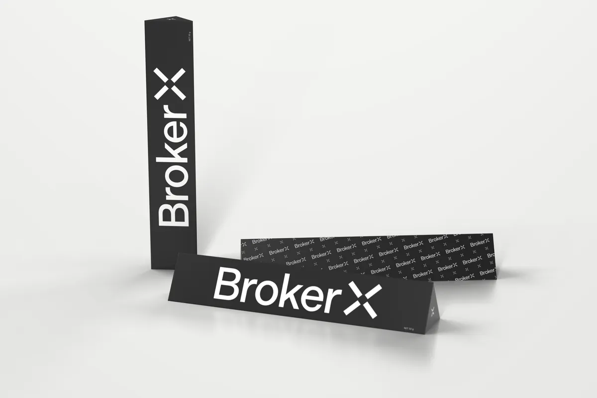 Render of Broker X branded Toblerone bars in black with a large white Broker X logo, one standing upright and one showing the Broker X logo pattern side